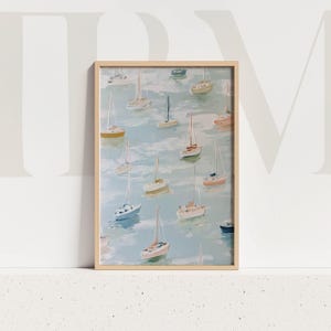 May include: A framed art print featuring a watercolor painting of numerous sailboats floating on a light blue sea. The boats are in various colors, including yellow, pink, and white, with beige wooden frame.