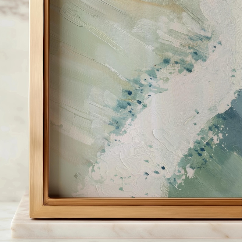 Puede incluir: Impresi&oacute;n art&iacute;stica abstracta en un marco dorado. La obra de arte presenta un dise&ntilde;o texturizado y en capas con tonos de blanco, verde y azul. El marco se asienta sobre una base de m&aacute;rmol blanco, agregando un toque de elegancia.