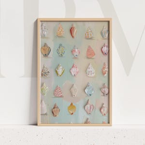 Może przedstawiać: Oprawione dzieło sztuki przedstawiające kolekcję malowanych muszli w różnych kolorach i kształtach. Muszle są ułożone na pastelowym tle z jasną drewnianą ramą. Dzieło nawiązuje do tematyki nadmorskiej lub plażowej.