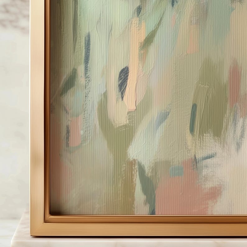 May include: Abstract art print in a gold frame. The artwork features brushstrokes in shades of green, peach, and blue. The painting has a textured appearance, with visible brush marks. The frame is a simple, modern design.