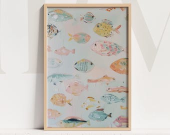 May include: A framed art print featuring a collection of colorful fish illustrations. The fish are painted in various colors, including yellow, pink, blue, and orange, against a light blue background. The artwork is encased in a light brown wooden frame.