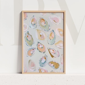 May include: Framed art print with an abstract oyster shell design in pink, yellow, and blue on a light grey backdrop. The print is set within a natural wood frame, offering a coastal or seaside theme, suitable for home decor.