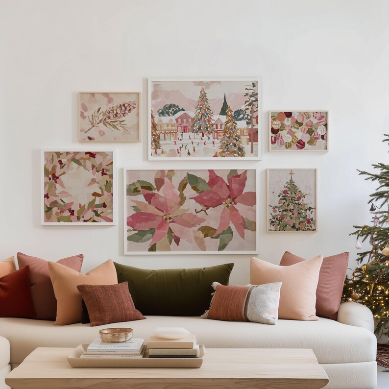 May include: A collection of framed watercolor art featuring Christmas themes, including poinsettias, a decorated tree, and a winter village scene. The art is displayed above a sofa with various throw pillows in shades of red, orange, and green.