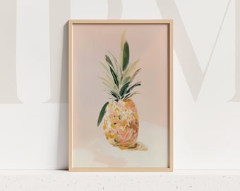 以下が含まれることがあります： パイナップルの水彩画が描かれた、額入りのアートプリント。パイナップルは黄色、オレンジ、ピンクの色合いで表現され、緑の葉が描かれています。背景はソフトピンクで、フレームは明るい木の色です。