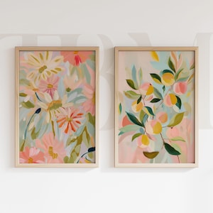 Pode incluir: Duas impressões de arte floral emolduradas. A impressão da esquerda apresenta um buquê de flores rosa, laranja e amarelas com folhas verdes e azuis. A impressão da direita retrata galhos com frutas amarelas e rosas e folhas verdes.