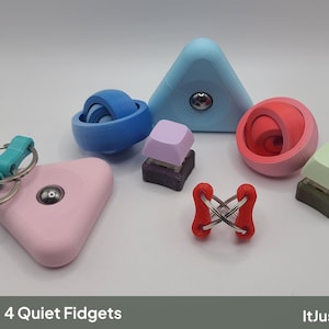 Op de afbeelding: Een verzameling fidget-speeltjes waaronder een lichtblauwe driehoekige spinner, een blauwe bolvormige spinner, een roze driehoekige sleutelhanger, een rood kruisvormig schakelspeeltje en twee mechanische toetsenbordtoetsen in lavendel en lichtgroen.