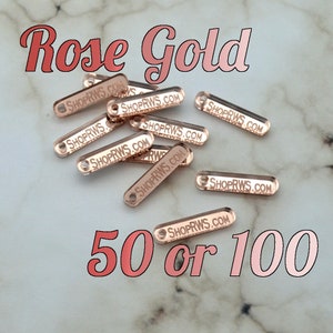 May include: Rose gold metal tags with the text "SHOPRWS.COM" engraved on them. The tags are available in quantities of 50 or 100.