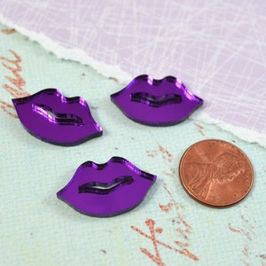 Peut inclure: Trois découpes de lèvres en acrylique miroir violet. Les lèvres ont la forme d'une moue classique.