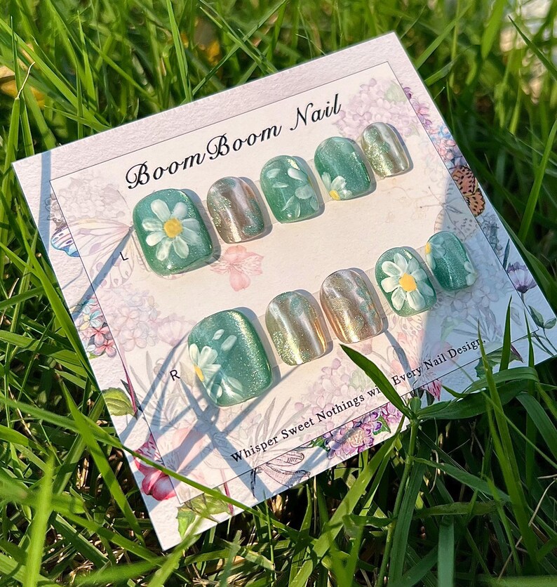 This nail set showcases a refreshing mint green base with delicate daisy accents, complemented by shimmering gold details. The design exudes a fresh and natural vibe, perfect for a cheerful and uplifting look.