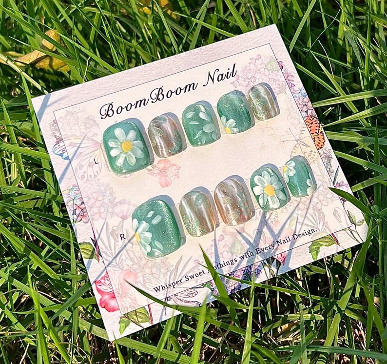 This nail set showcases a refreshing mint green base with delicate daisy accents, complemented by shimmering gold details. The design exudes a fresh and natural vibe, perfect for a cheerful and uplifting look.