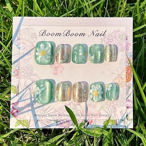 This nail set showcases a refreshing mint green base with delicate daisy accents, complemented by shimmering gold details. The design exudes a fresh and natural vibe, perfect for a cheerful and uplifting look.