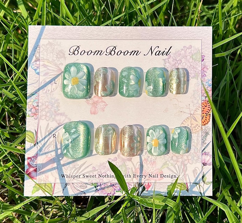 This nail set showcases a refreshing mint green base with delicate daisy accents, complemented by shimmering gold details. The design exudes a fresh and natural vibe, perfect for a cheerful and uplifting look.