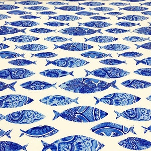 Puede incluir: Tela blanca con un patrón repetitivo de peces azules. Los peces son estilizados y tienen un diseño detallado.