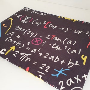 May include: A black laptop sleeve featuring a pattern of white, red, yellow, and blue mathematical equations and symbols. The equations include formulas, trigonometric functions, and algebraic expressions. The sleeve is rectangular and made of fabric.