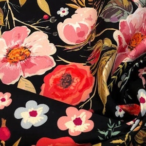 May include: Black fabric with a floral print featuring pink, red, and white flowers. The flowers are arranged in a random pattern on a black background.