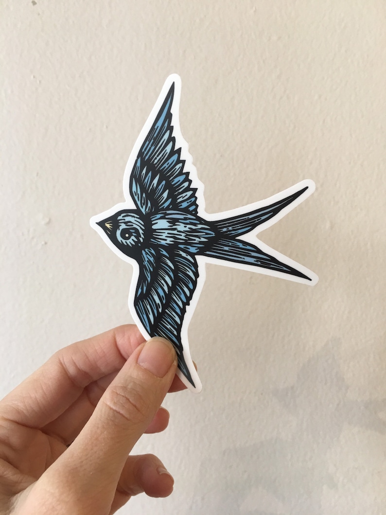 May include: A blue and white swallow bird sticker with a detailed design. The sticker is cut out and ready to be applied to a surface.