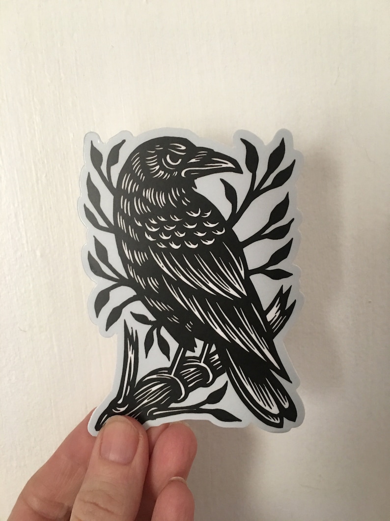 Peut inclure: Autocollant noir et blanc d'un corbeau perch&eacute; sur une branche. Le corbeau est repr&eacute;sent&eacute; dans un style de gravure sur bois d&eacute;taill&eacute;.