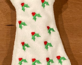May include: A white doll dress with a green collar and red and green holly embroidery.