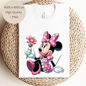 May include: A white t-shirt with a pink and white cartoon image of Minnie Mouse holding a pink flower. Minnie Mouse is wearing a pink dress with white polka dots and a pink bow with white polka dots.