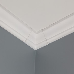 May include: A corner of a room featuring white crown molding against a gray wall and white ceiling. The molding has a layered design with a decorative profile, creating a clean, architectural detail.