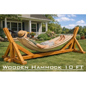 Puede incluir: Una hamaca de madera con una cama de tela beige, sostenida por un marco de madera. El marco es de madera teñida y mide aproximadamente 305 cm de largo. Una persona se relaja en la hamaca sobre un césped.