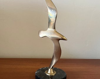 Brass seagull in flight mounted on a dark grey and white marble base. Beach House decor 1970s