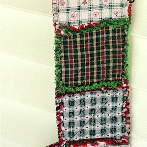 Może przedstawiać: Ręcznie robiona świąteczna skarpeta z patchworkowym wzorem. Skarpeta wykonana jest z różnych tkanin w kratę w kolorze czerwonym, zielonym i białym. Widoczny jest tekst "Tutorial/Instructions to MAKE this type of Christmas Stocking".