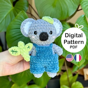 May include: A crocheted koala amigurumi toy wearing blue overalls and holding a green leaf. The toy is gray with black eyes and a pink nose. The text "Digital Pattern PDF" is visible in the image.