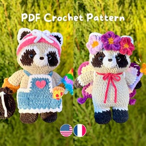 Peut inclure: Deux poupées ratons laveurs crochetées. L'une porte un bandeau rose et une salopette bleue avec un cœur. L'autre a une couronne de fleurs et des ailes. Le texte "PDF Crochet Pattern" est en haut.