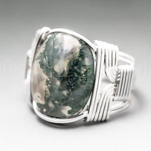 May include: A silver wire wrapped ring with a green and white moss agate stone.