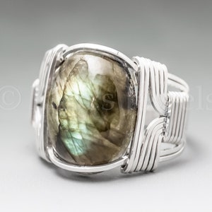 May include: A silver wire wrapped ring with a large, green and gray labradorite gemstone.