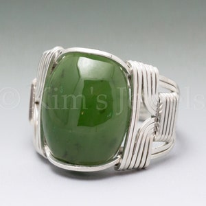May include: A silver ring with a green jade stone set in a wire-wrapped design.