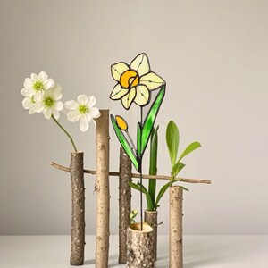 Stained glass daffodil flower art displayed in a wooden log vase – March birth flower decor.
