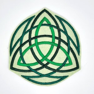 May include: A green and white felt Celtic knot patch with a triangular shape. The knot is a traditional Irish symbol of love, friendship, and faith.