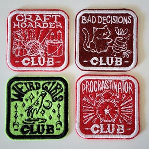May include: Four embroidered patches with white stitching and text. The patches are red, maroon, and green. The red patches read "Craft Hoarder Club" and "Procrastinator Club". The maroon patch reads "Bad Decisions Club". The green patch reads "Weird Girls Club".
