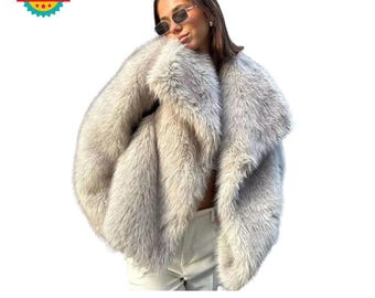 May include: A white faux fur coat with a large, dramatic collar. The coat is made of soft, fluffy fur and has a relaxed, oversized fit.