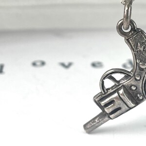 Vintage Miniature Sterling Silver Revolver gun charm intricate details of a classic firearm, with a textured grip and barrel.  Its antique look Western-themed jewellery or for fans of vintage weaponry. miniature silver pistol, cowboy charm, cowgirl