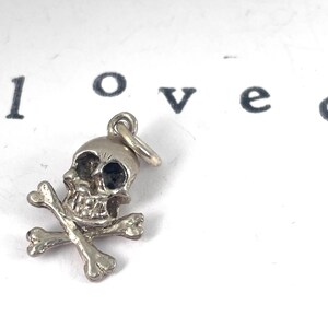 Vintage Sterling Silver Skull and crossbones charm, mortality, danger, living fearlessly "memento mori,",  Latin for "remember that you must die."  living in the present moment.  strength, resilience, embracing mortality with boldness.