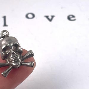 Vintage Sterling Silver Skull and crossbones puffed charm, mortality, danger, living fearlessly "memento mori,",  Latin for "remember that you must die."  living in the present moment.  strength, resilience, embracing mortality with boldness.