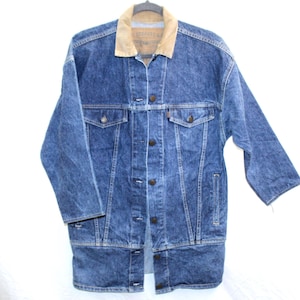 May include: A vintage blue denim jacket with a tan corduroy collar. The jacket has a button-up front, two chest pockets, and two side pockets. The jacket is a medium wash denim.