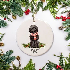 Personalized Dog ornament, featuring a black cockapoo labradoodle in a holiday scarf. The ornament is ceramic, and comes with a gold string and a free gift box. We can include a special text message on the back