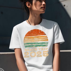 Camiseta unisex vintage de viaje a la playa 2025, camiseta gráfica retro de olas de sol, estética de póster de surf desgastado, tonos playeros descoloridos, fuente estilo años 70.