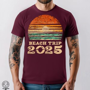 Camiseta unisex vintage de viaje a la playa 2025, camiseta gráfica retro de olas de sol, estética de póster de surf desgastado, tonos playeros descoloridos, fuente estilo años 70.