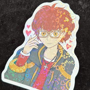 May include: Holographic sticker featuring an anime-style character with red hair, glasses, and a cross necklace. The character is wearing a red shirt, a black jacket with gold accents, and a design of hearts. The sticker has a white border and is on a black surface.