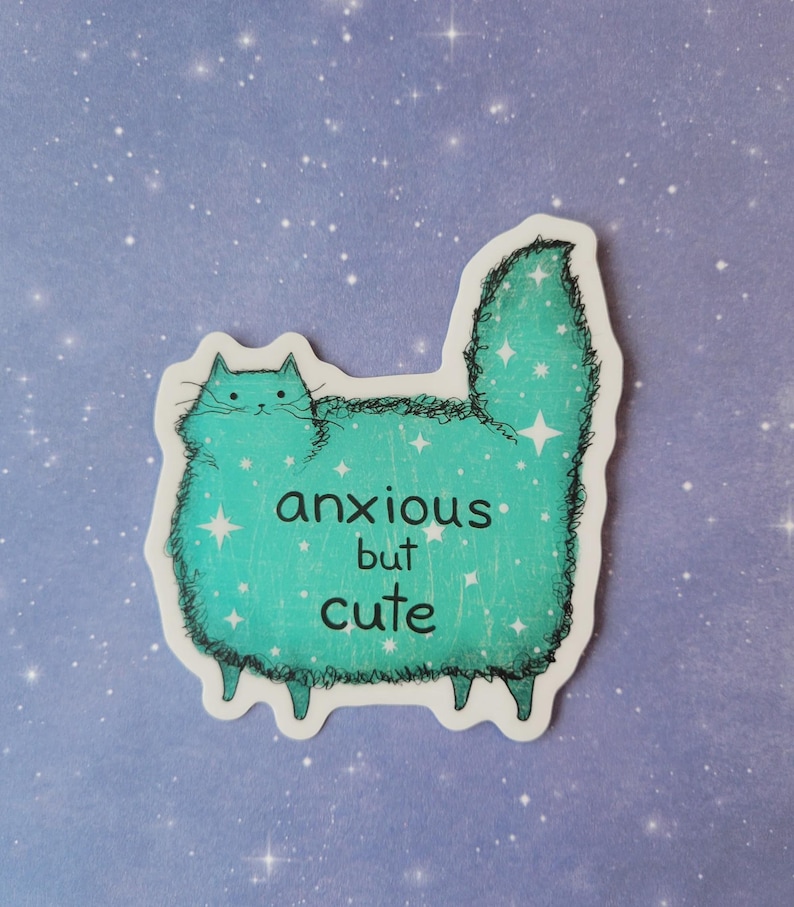 以下が含まれることがあります： 水色の猫のイラストと「anxious but cute」の文字が入ったステッカー。猫は星のアクセントと白い輪郭を持つふわふわの体を持っています。背景は、白い星の詳細を持つ薄紫です。