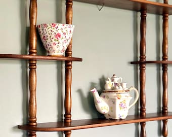 Estantería vintage de madera con forma de huso, ideal para exhibir objetos en la pared o para decorar.