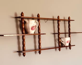 Estantería de pared vintage de madera con forma de huso, ideal para miniaturas y pequeños objetos de colección. Medidas: 68,5 cm x 23 cm x 5 cm.