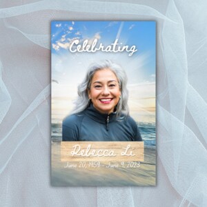 May include: A memorial card with a blue sky and ocean background. The card features a photo of a woman with gray hair and a white inscription that reads "Celebrating Rebecca Li June 20, 1959 - June 9, 2023".