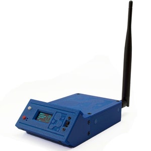 May include: A blue device with a black antenna, a small screen displaying text, and a red button. The device has a textured surface and several small black screws.