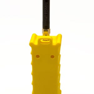 May include: A yellow plastic case with a black antenna attached to the top. The antenna has the text "DIYmall 915MHz" printed on it.